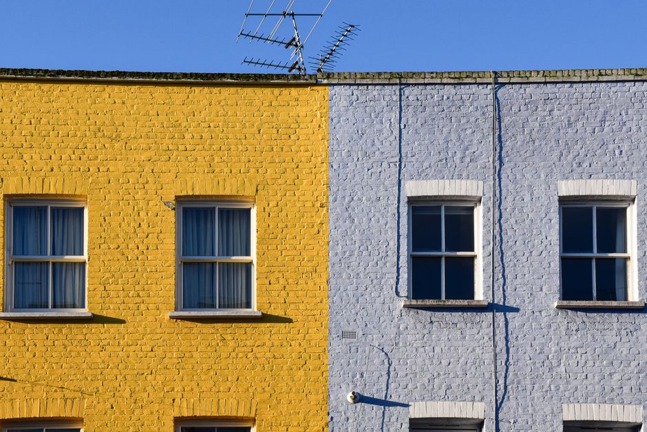 Painted house wall with windows in daylight