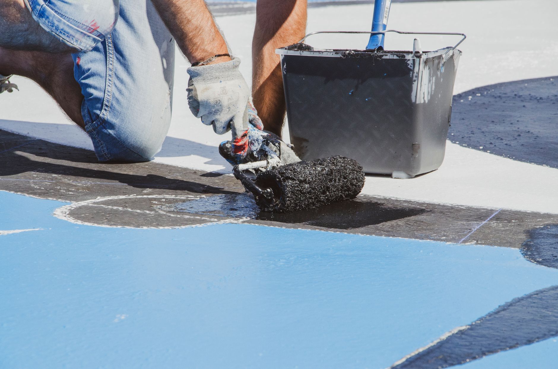 A person painting an exterior wall