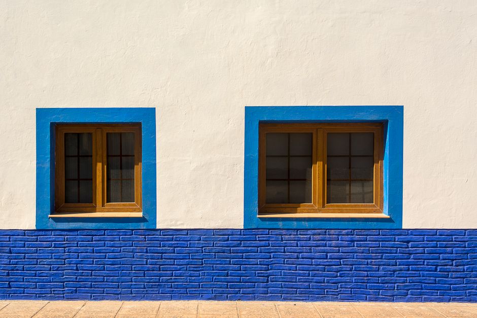 Painted house wall with blue window frames